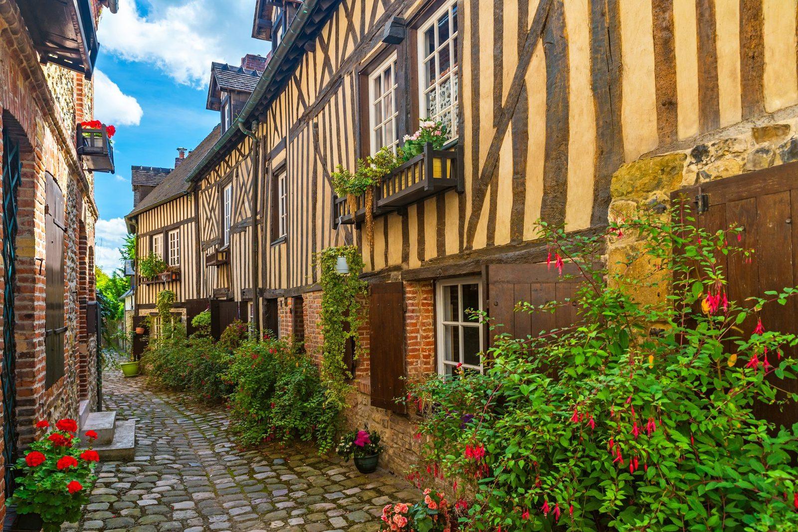 Ruelle pavée à colombages fleurie au cœur d'Honfleur