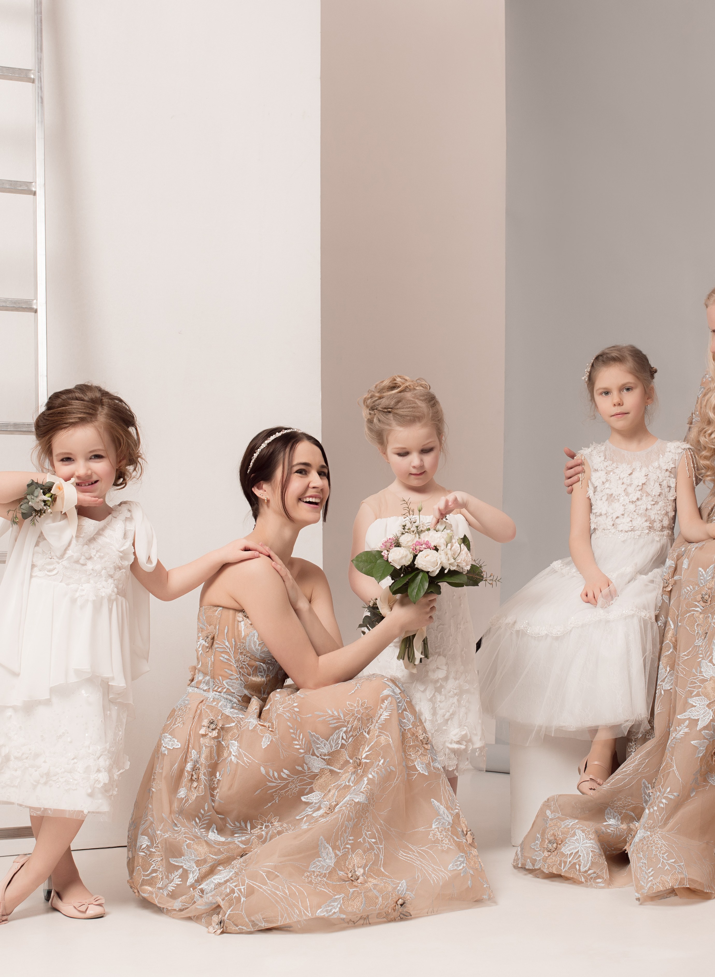 Petite fille en robe cortège coordonnée aux couleurs du mariage, portant un ruban assorti et un boléro léger