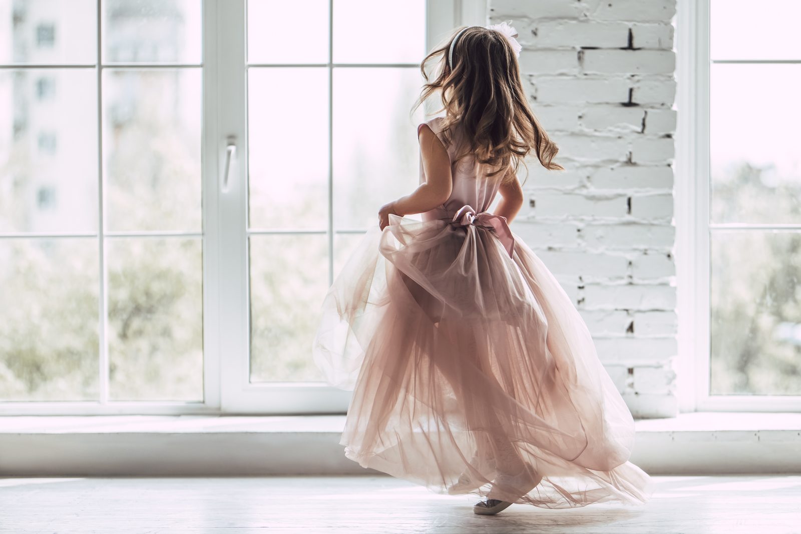 Petite fille en robe de fête en tulle blush